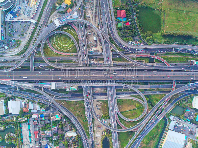 鸟瞰图，道路环岛，高速公路与汽车停车场在泰国的城市。美丽的街道，市中心，城市景观，顶视图。背景