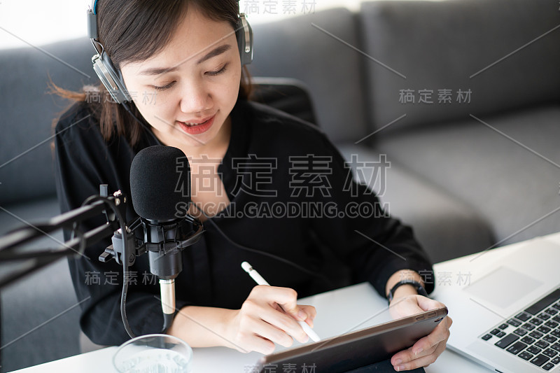 一个亚洲年轻女子在网上播客站做播客。