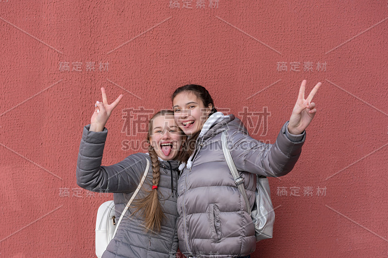 女孩们笑着展示舌头和胜利手势