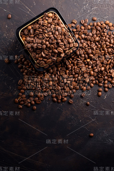 咖啡豆在金属黑罐上深棕色的背景俯视图