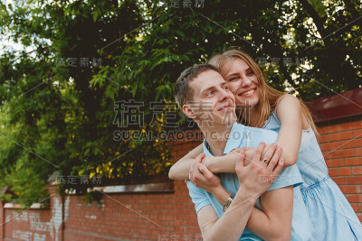 幸福的夫妇拥抱笑砖墙背景肖像