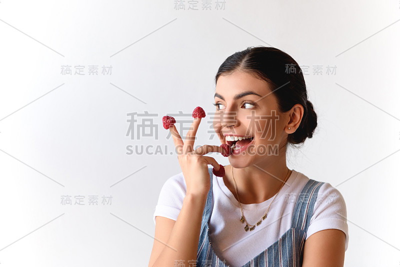 手指上有树莓的女人