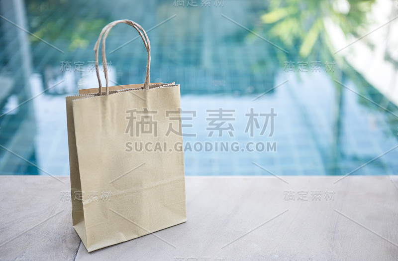 游泳池边的棕色纸袋