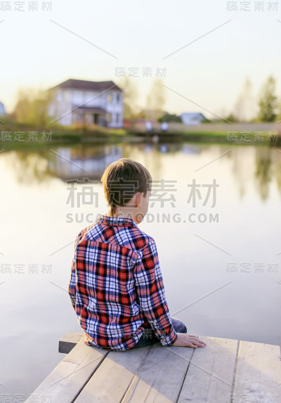 男孩看着池塘里的水