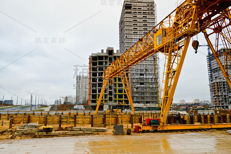 高重黄色金属铁承重建筑固定式工业强力桥式龙门起重机，用于在现代建筑工地的建筑物和房屋上提升货物