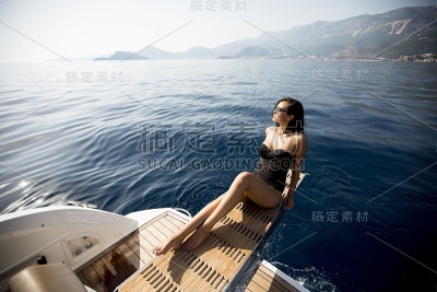 年轻漂亮的女人在游艇上休息