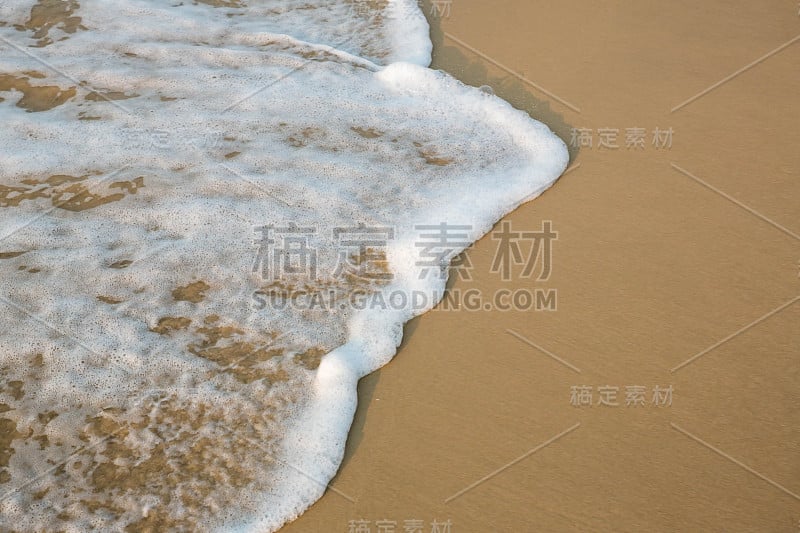 柔软的蓝色海浪在沙滩上。背景。有选择性的重点。海滩和热带海洋白色泡沫的海滩。对图片底部进行软聚焦。