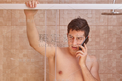 严肃的白人在浴室里打电话。