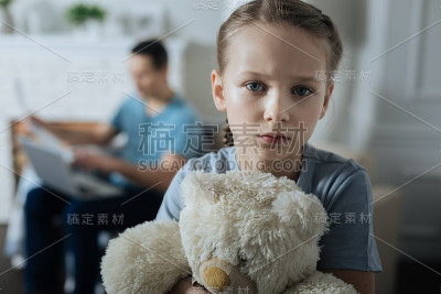 悲伤的小女孩拿着她的玩具