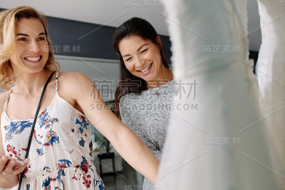 新娘与店员一起购买婚纱