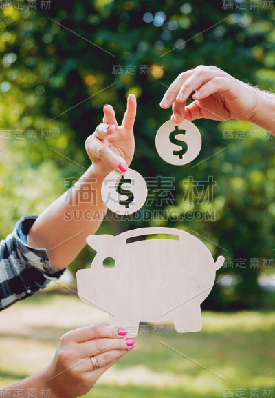 手把硬币放在存钱罐里。的概念。在户外。夏季。家庭