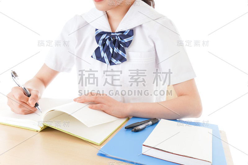 穿制服的年轻学生在书桌前学习