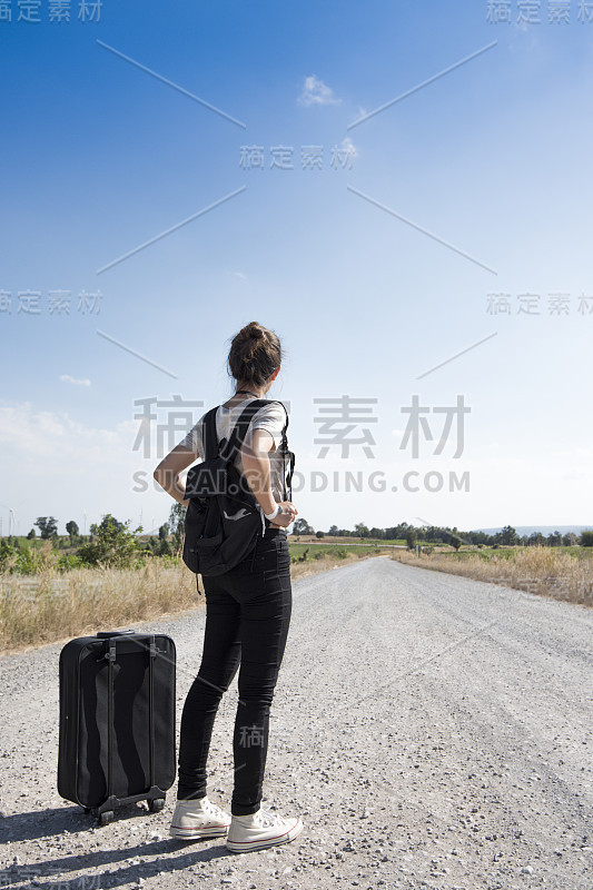 年轻女孩带着包旅行等公共汽车