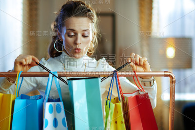 女人在看挂在铜质衣架上的购物袋