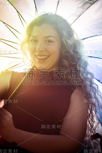 一个在阳光明媚的日子里打着伞的漂亮女人
