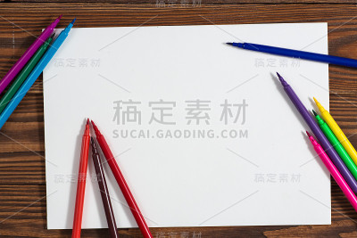彩色蜡笔和一张纸笔记本木头