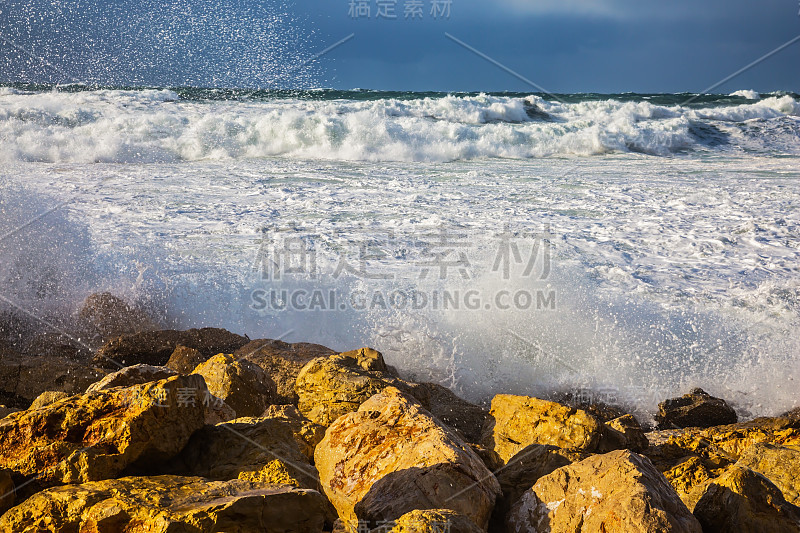 泡沫状的巨浪拍打着岸边的岩石