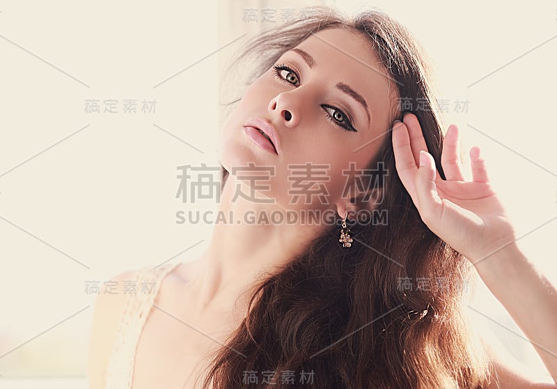 美丽的女人用绿色的眼睛抚摸着长长的头发