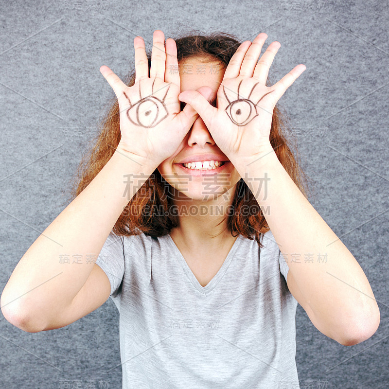 手掌上画着眼睛的有趣女孩。四月愚人节的玩笑