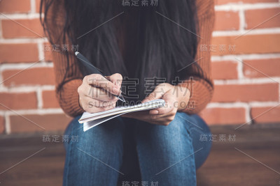 女人拿着笔记本坐着
