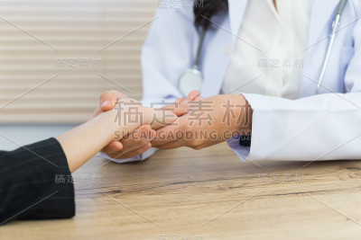 一个医生的近距离握住病人的手做基本的医疗检查和诊断。