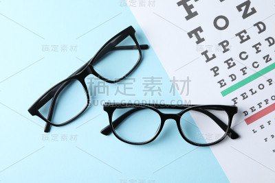 蓝色背景上的眼镜和视力检查表，俯视图
