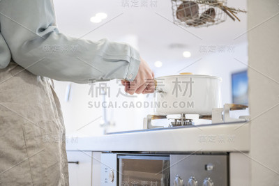 在煤气炉上做饭的年轻女人的手