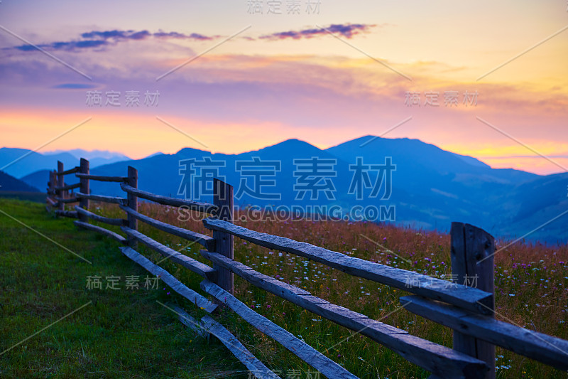 日落和木栅栏沿牧场，大自然，夏季景观喀尔巴阡山脉，云杉上的山丘，美丽的多云天空