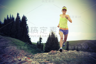 健康年轻女子越野跑在美丽的山峰上
