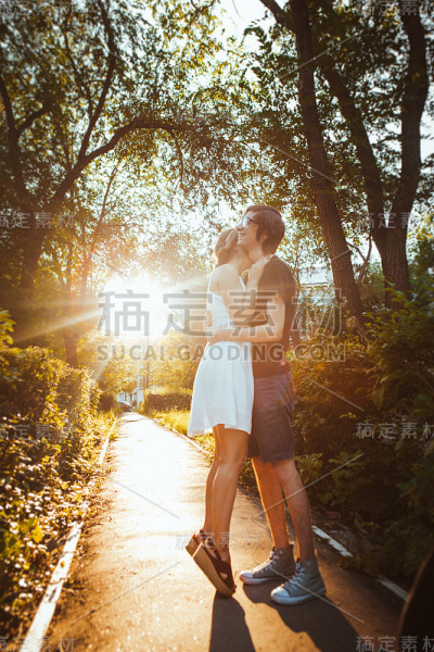 男孩和女孩在公园的背景下拥抱