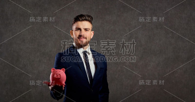 一个穿着西装拿着存钱罐的男人