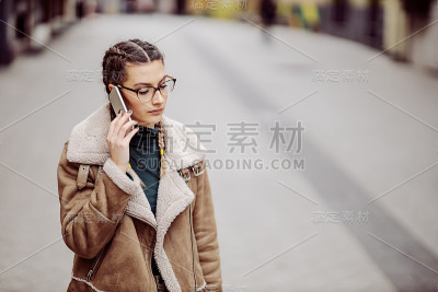 迷人的黑发女人在街上打电话。她是担心。