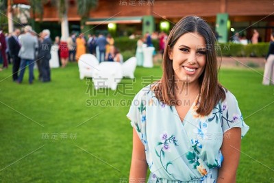 年轻美丽和优雅的女人与婚礼的客人服装微笑快乐和愉快
