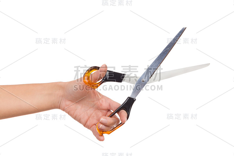 女人的手握剪刀和切割的特写。
