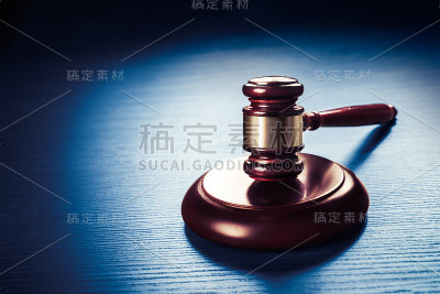 法官的小木槌放在蓝色的木头背景上