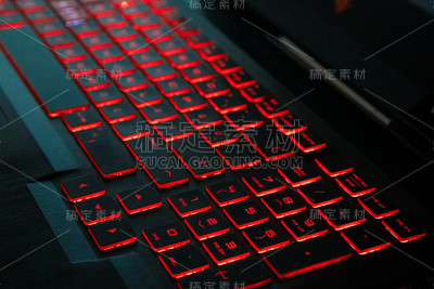红色背光在现代键盘上的游戏笔记本在黑暗中