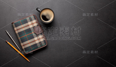 办公室桌子，桌上有记事本和咖啡