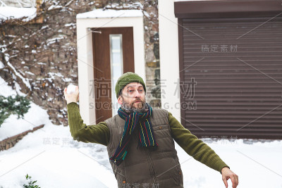 帽子上有胡子的人在院子里扔雪球