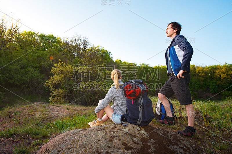 男人和女人的旅行者户外，一对徒步旅行者与背包休息在他们的路上，旅行，假期，假日和冒险的概念，森林山景