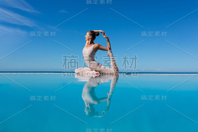 在泳池边做瑜伽的女人。