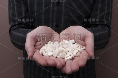 拿着一堆药片和胶囊的白人男人