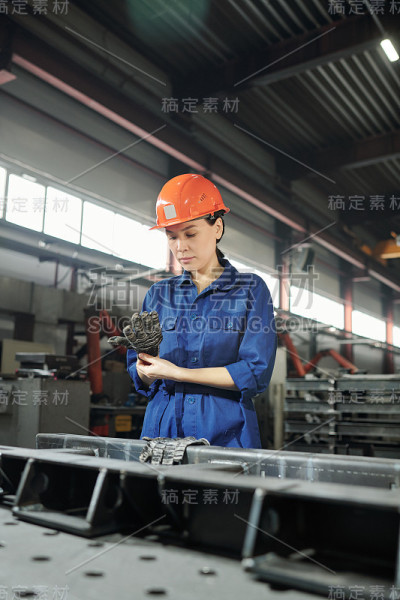 年轻严肃的女工程师在上班前戴上手套