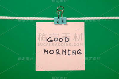 晒衣绳上的粉色纸条，彩色背景上写着“早上好”