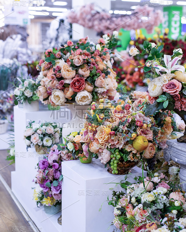 美丽的花束人造玫瑰与树叶和水果，装饰人造花粉色丁香玫瑰花束。垂直背景花店