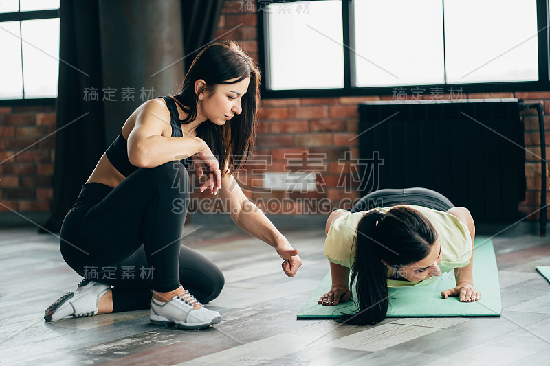 女性在私人教练的支持下锻炼