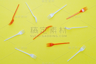 黄色背景的塑料叉子。