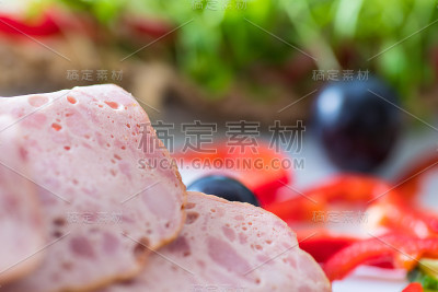 晚餐面包，肝奶酪和各种蔬菜配菜作为模糊的背景