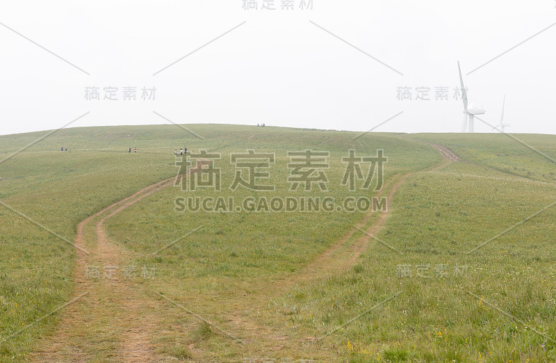 在一个多雾的夏日里，游客们在太岳山的华坡，用风力发电机爬上高山草甸的顶端