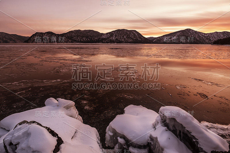 日落之上冰雪覆盖的湖面，冬季群山景观