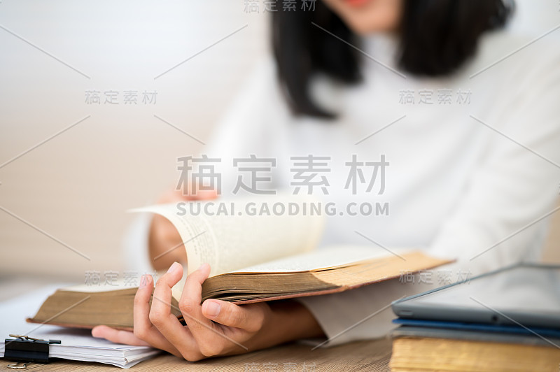 一位穿着白衬衫的亚洲女学生坐在大学里读书